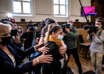 Accused Valerie Bacot (C/yellow scarf) arrives flanked by her family and surrounded by journalists the Chalon-sur-Saone Courthouse, on June 21, 2021, central-eastern France, prior to the opening hearing of her trial on charges of murdering her stepfather turned husband, who she claimed abused her since she was 12. (Photo by JEFF PACHOUD / AFP)