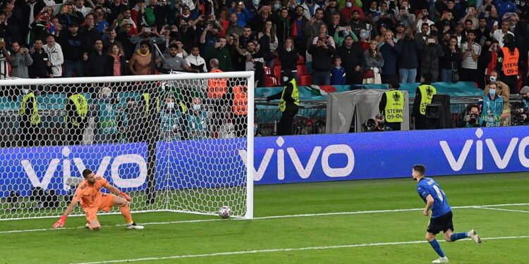 Italy's midfielder Jorginho (R) shoots and scores the winning goal past Spain's goalkeeper Unai Simon in a penalty shootout during the UEFA EURO 2020 semi-final football match between Italy and Spain at Wembley Stadium in London on July 6, 2021. (Photo by FACUNDO ARRIZABALAGA / POOL / AFP)