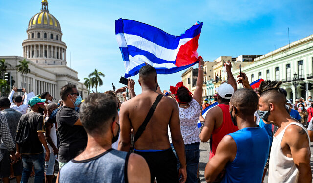 Cubans are seen outside Havana's Capitol during a demonstration against the government of Cuban President Miguel Diaz-Canel in Havana, on July 11, 2021. - Thousands of Cubans took part in rare protests Sunday against the communist government, marching through a town chanting "Down with the dictatorship" and "We want liberty." (Photo by YAMIL LAGE / AFP)