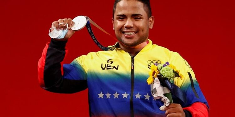 El venezolano Keydomar Giovanni Vallenilla Sanchez celebra en el podio tras conseguir la medalla de plata en la prueba de levantamiento de pesas masculino de 96 kg durante los Juegos Olímpicos 2020, este sábado en el Foro Internacional de Tokio (Japón). EFE/José Méndez