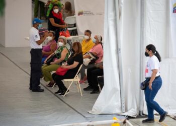 CARACAS (VENEZUELA), 02/08/2021.- Personas en un centro de vacunación, el 30 de julio, en Caracas. A la lentitud de la vacunación contra la covid-19 en Venezuela, se sumó la escasez de la Sputnik V, el fármaco por el que el Gobierno acordó con Rusia el envío de diez millones de unidades y del que solo se recibieron, de forma pública, 1.430.000. La vacuna parece hoy un fantasma, mientras un número indeterminado de ciudadanos esperan, sin certezas, la segunda dosis. EFE/RAYNER PEÑA R.