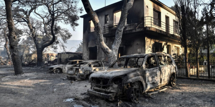 This photograph taken on August 4, 2021 shows burned cars at a burned horse riding facility in Varybombi, a suburb north of Athens, as fires broke out at the foot of Mount Parnes, 30 kilometres north of Athens. - Greek firefighters said in a statement that they hope to bring a forest fire blazing near Athens under control "in the coming hours". More than 500 firefighters, a dozen water-bombing planes and five helicopters have been battling the blazes outside the capital since August 3 afternoon. (Photo by LOUISA GOULIAMAKI / AFP)