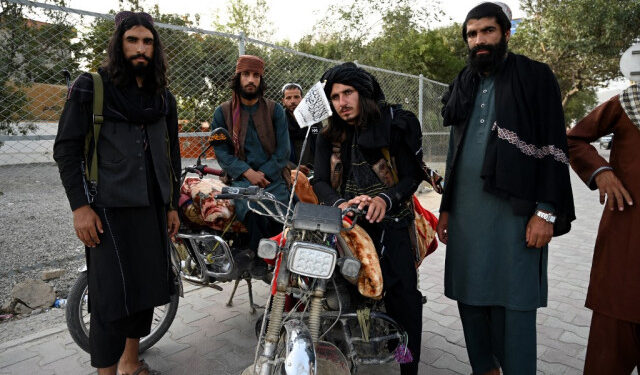 Taliban fighters stand along a road in Kabul on August 18, 2021, after the Taliban's military takeover of Afghanistan. (Photo by Wakil KOHSAR / AFP)