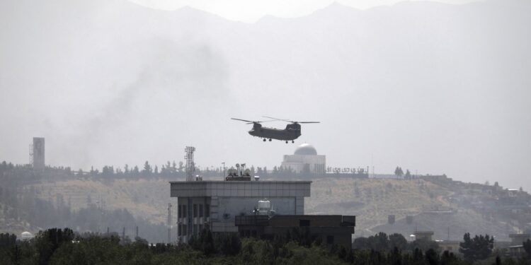 A U.S.Chinook helicopter flies over the U.S. Embassy, in Kabul, Afghanistan, Sunday, Aug. 15, 2021. Helicopters are landing at the U.S. Embassy in Kabul as diplomatic vehicles leave the compound amid the Taliban advanced on the Afghan capital. (AP Photo/Rahmat Gul)