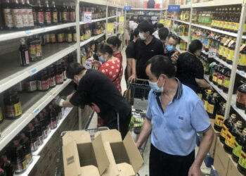 This photo taken on August 2, 2021 shows people buying items at a supermarket in Wuhan, in China's central Hubei province, as authorities said they would test its entire population for Covid-19 after the central Chinese city where the coronavirus emerged reported its first local infections in more than a year. (Photo by STR / AFP) / China OUT