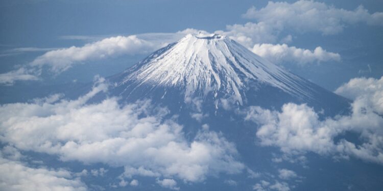 This picture shows Mount Fuji, Japan's highest mountain at 3,776 meters (12,388 feet), seen from the window of a passenger aircraft en route to Kagoshima on May 14, 2021. (Photo by Charly TRIBALLEAU / AFP)