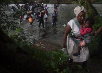 Una mujer migrante haitiana carga a un niño mientras cruza la selva colombiana del Darién, cerca de Acandi, departamento de Chocó, en dirección a Panamá, el 26 de septiembre de 2021
© AFP Raul ARBOLEDA