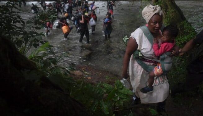 Una mujer migrante haitiana carga a un niño mientras cruza la selva colombiana del Darién, cerca de Acandi, departamento de Chocó, en dirección a Panamá, el 26 de septiembre de 2021
© AFP Raul ARBOLEDA