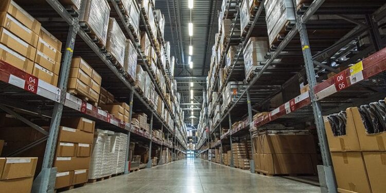 Large warehouse logistic or distribution center. Interior of warehouse with rows of shelves with big boxes