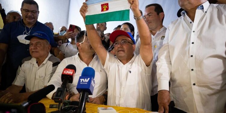 Sergio Garrido (c), muestra la bandera del estado durante una rueda de prensa hoy, desde su comando de Campaña en Barinas (Venezuela). El opositor venezolano Sergio Garrido arrebató al oficialismo la Gobernación del estado Barinas, cuna de Hugo Chávez, al ganar las elecciones regionales de este domingo, que se repitieron por orden del Supremo, que anuló los resultados de los comicios del pasado 21 de noviembre, en los que ya había vencido, por un estrecho margen, el antichavismo. EFE/ Rayner Peña R.