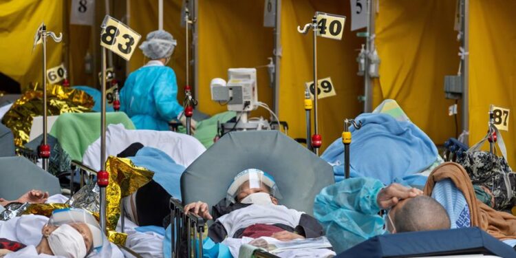 Pacientes con síntomas de Covid-19 yacen en camas fuera del Departamento de Accidentes y Emergencias del Centro Médico Caritas en Hong Kong, China. EFE/EPA/MIGUEL CANDELA