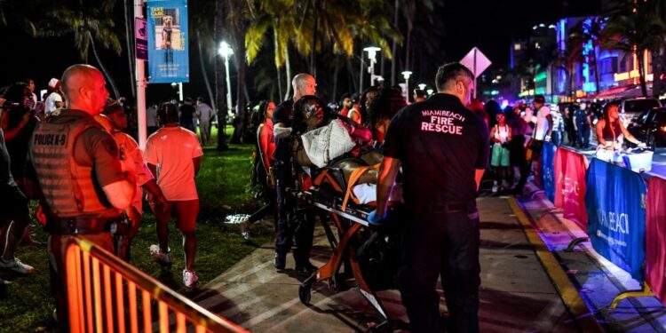 Miami Beach Fire Rescue transport a woman on a stretcher on Ocean Drive in Miami Beach, Florida on March 17, 2022. - Music, dancing, alcohol and tiny swimsuits -- spring vacation in the United States, popularly known as "spring break," brings thousands of young people to south Florida every year for a few days of uncontrolled fun, much to the chagrin of residents in cities like Miami Beach. (Photo by CHANDAN KHANNA / AFP)
