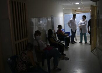 Health workers stand at the front of a line of people waiting for a shot of the Russian COVID-19 vaccine Sputnik V at the Guarenas Guatire General Hospital in Guatire, Venezuela, Thursday, April 8, 2021. The hospital started vaccinating seniors on Thursday who belong to the "Sistema Patria," or "Patriotic System," a government program that also offers food aid and subsidized gas prices. (AP Photo/Matias Delacroix)