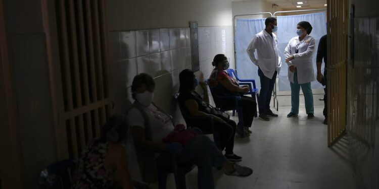 Health workers stand at the front of a line of people waiting for a shot of the Russian COVID-19 vaccine Sputnik V at the Guarenas Guatire General Hospital in Guatire, Venezuela, Thursday, April 8, 2021. The hospital started vaccinating seniors on Thursday who belong to the "Sistema Patria," or "Patriotic System," a government program that also offers food aid and subsidized gas prices. (AP Photo/Matias Delacroix)