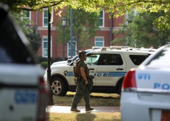 A medic walks between police cars after a shooting on the campus of University of North Carolina Charlotte in University City, Charlotte, on April 30, 2019. - Six people were shot, two of them died on the University of North Carolina Charlotte campus. One person was taken into custody, according to police sources. (Photo by Logan Cyrus / AFP)