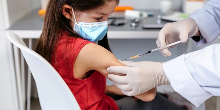 Little girl receiving coronavirus vaccine at doctor's office