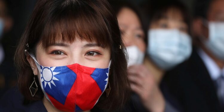 A staff wears a face mask with a Taiwanese flag design, as protection due to the coronavirus disease (COVID-19) outbreak, at a factory for non woven filter fabric used to make surgical face masks, in Taoyuan, Taiwan, March 30, 2020. REUTERS/Ann Wang