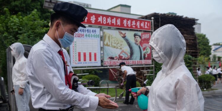 Students of the Pyongyang Jang Chol Gu University of Commerce receives hand sanitiser before entering the campus, as part of preventative measures against Covid-19, in Pyongyang on August 11, 2021. (Photo by KIM Won Jin / AFP) (Photo by KIM WON JIN/AFP via Getty Images)