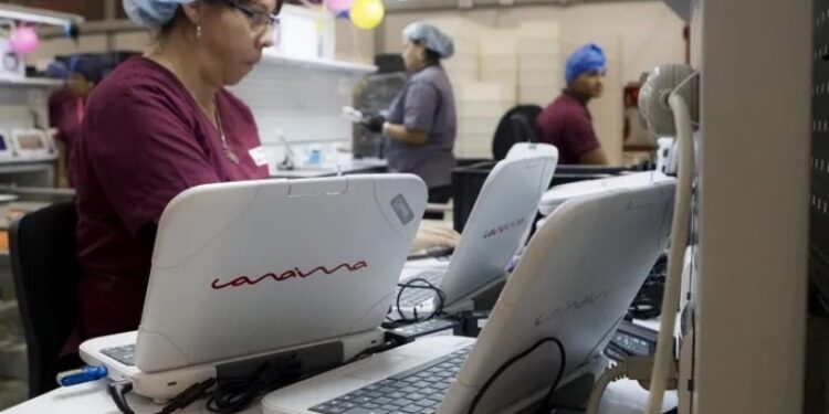 Trabajadores de la industria Canaima ensamblan computadores portátiles. Foto EFE.