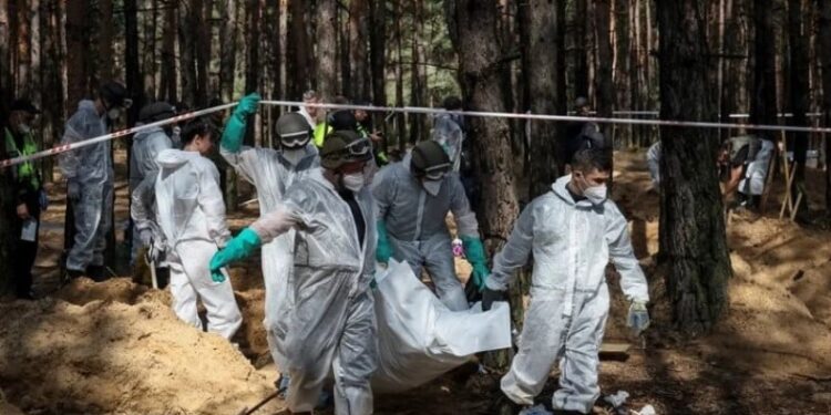 Equipo del servicio de emergencia de Ucrania levantan cuerpos de fosas comunes en Izium Ucrania. Foto agencias.