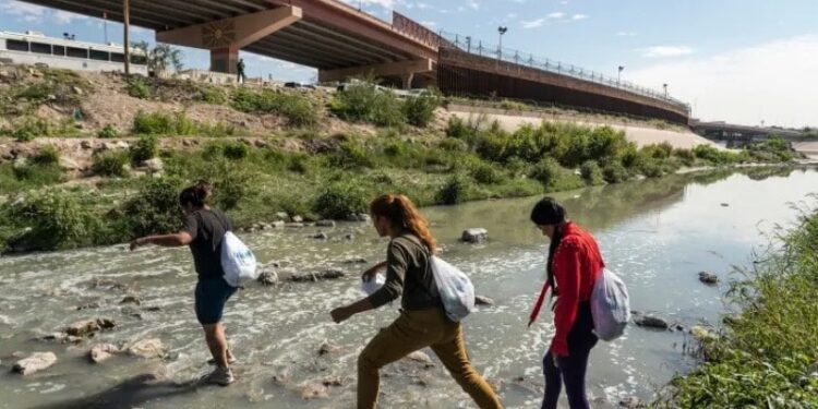 Migrantes venezolanos que buscan asilo Angie Pina (izquierda), su pareja (centro) y su amigo cruzan el río Bravo hacia los EE. UU. nuevamente después de haber sido expulsados ​​de los EE. UU. bajo el Título 42 días antes.
