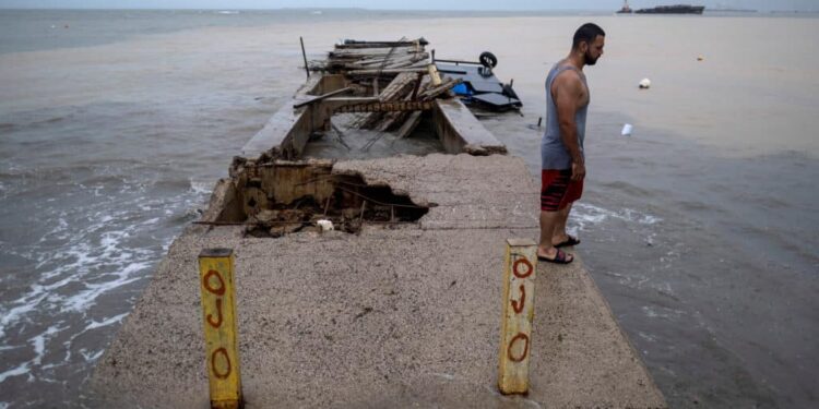 A man stands over a pier affected by the passing of Hurricane Fiona in Penuelas, Puerto Rico September 19, 2022.  REUTERS/Ricardo Arduengo
