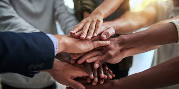 Cropped shot of a group of businesspeople joining their hands in solidarity