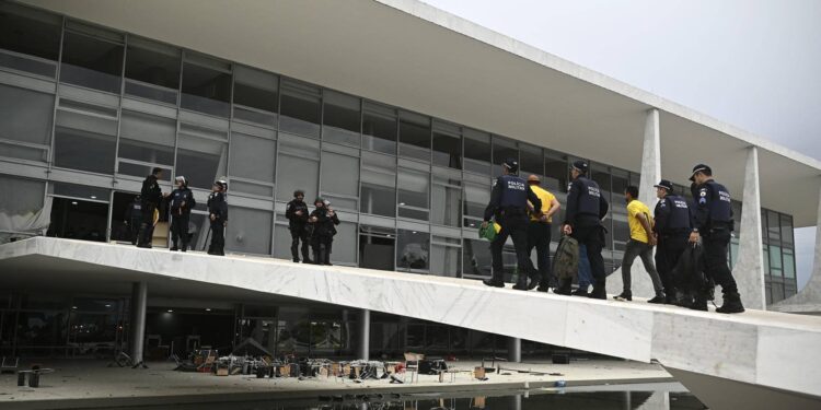 AME4954. BRASILIA (BRASIL), 08/01/2023.- Las fuerzas de seguridad detiene a los seguidores del expresidente brasileño Jair Bolsonaro que invadieron hoy, el Palacio de Planalto, sede del Ejecutivo, y la Corte Suprema, después de haber irrumpido antes en el Congreso Nacional en actos golpistas contra el presidente Luiz Inácio Lula da Silva, en Brasilia (Brasil). Decenas de agentes subieron la rampa que da acceso a la primera planta del palacio disparando gases lacrimógenos, mientras otro grupo de uniformados rodeaba el edificio. Seguidores del expresidente brasileño Jair Bolsonaro invadieron este domingo el Palacio de Planalto, sede del Ejecutivo, y la Corte Suprema, después de haber irrumpido antes en el Congreso Nacional en actos golpistas contra el presidente Luiz Inácio Lula da Silva. EFE/ Andre Borges