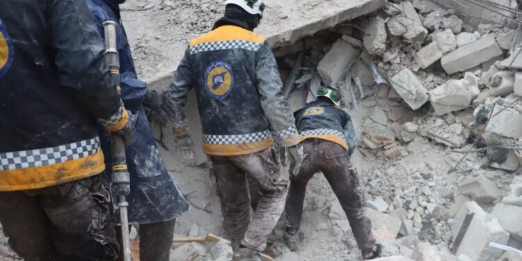 Los rescatistas buscan sobrevivientes bajo los escombros, luego de un terremoto, en Al Atarib, Siria.