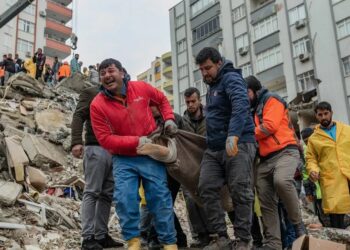 Los rescatistas llevan un cuerpo encontrado entre los escombros en Adana.