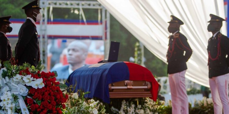 AME4616. CAP-HAITIEN (HAITÍ), 23/07/2021.- Soldados custodian el féretro con el cuerpo del presidente Jovenel Moise (pantalla) durante el inicio de su ceremonia fúnebre hoy, en Cap-Haitien (Haití). El velatorio en honor al presidente de Haití, Jovenel Moise, comenzó este viernes en la ciudad de Cap-Haitien, en el norte del país, horas antes de que tenga lugar el entierro del mandatario, quien fue asesinado el pasado 7 de julio. Las honras fúnebres comenzaron con dos horas de retraso con respecto al horario previsto y tienen lugar en los jardines de la Habitation Village SOS, residencia privada de la familia Moise a las afueras de Cap-Haitien, que está custodiada por un fuerte aparato de seguridad. EFE/ Jean Marc Hervé Abélard