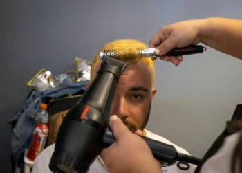 Un seguidor de la selección de béisbol de Puerto Rico se hace teñir el cabello junto con otras decenas de personas, para romper el récord Guinness en Guaynabo, el viernes 10 de marzo de 2023 (AP Foto/Alejandro Granadillo) AP (Alejandro Granadillo/AP)