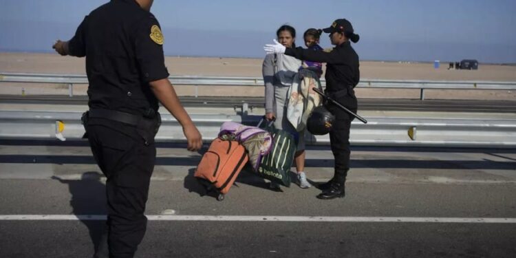 Un migrante venezolano y un niño son detenidos por la policía en Tacna, Perú, el viernes 28 de abril de 2023. (AP FotoMartín Mejía)(Martín Mejía  Associated Press)