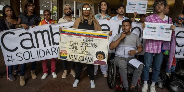 Un grupo de personas participan en una manifestación por derechos de identidad de genero en las inmediaciones del Consejo Nacional Electoral (CNE) hoy, en Caracas (Venezuela). Decenas de activistas LGBTI en Venezuela reiteraron este miércoles las exigencias por sus derechos, durante un acto en una plaza de Caracas, donde izaron la bandera del arcoíris que representa a este colectivo, a propósito del Internacional contra la Homofobia, la Bifobia y la Transfobia. EFE/ Miguel Gutierrez