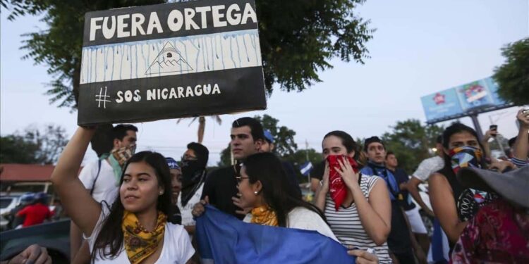 A woman holds a sign that reads in Spanish  Ortega Out   during a protest against the government of President Daniel Ortega  in Managua  Nicaragua  Sunday  April 11  2018  President Ortega has withdrawn changes to the social security system that touched off protests across the Central American nation that escalated into clashes with police leaving dozens dead   AP Photo Alfredo Zuniga