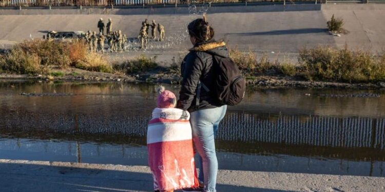 Una migrante y su hija observan a militares estadounidenses desde el lado mexicano de la frontera, en Ciudad Juárez.
JOHN MOORE (GETTY IMAGES)