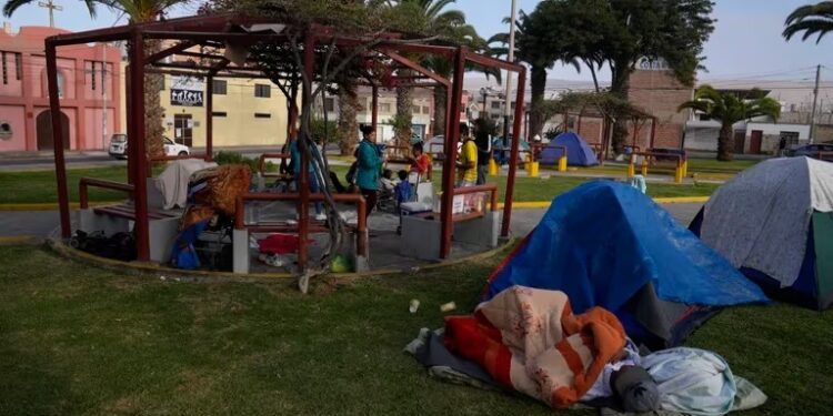 Migrantes venezolanos acampan en un parque en Tacna, Perú, el sábado 29 de abril de 2023. Una crisis migratoria en la frontera entre Chile y Perú se intensificó mientras cientos de migrantes permanecían varados al no poder cruzar a Perú. (Foto AP/Martín Mejía)