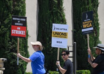Hollywood writers and their supporters from the SAG AFTRA actors' union walk the picket line outside Warner Bros Studios in Burbank, California, June 30, 2023. Hollywood's summer of discontent could dramatically escalate this weekend, with actors ready to join writers in a massive "double strike" that would bring nearly all US film and television productions to a halt. The Screen Actors Guild (SAG-AFTRA) is locked in last-minute negotiations with the likes of Netflix and Disney, with the deadline fast approaching at midnight Friday (0700 GMT Saturday). (Photo by Robyn Beck / AFP)