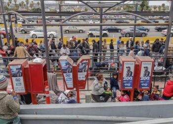 Migrantes de diferentes nacionalidades, descansan en la entrada de la garita peatonal de San Ysidro, Tujuana México. Foto EFE