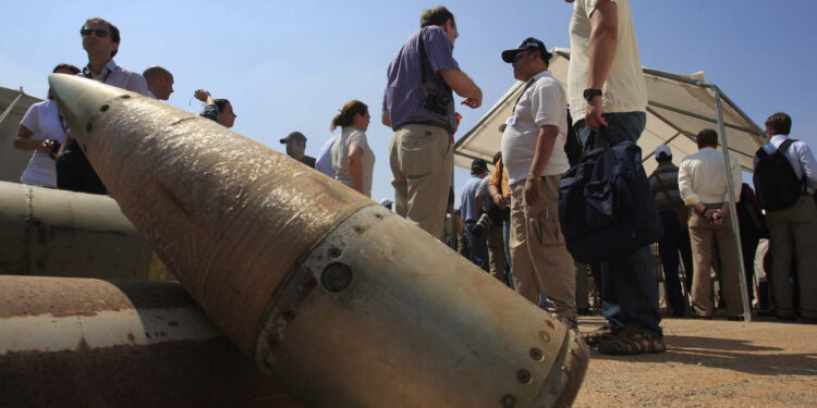 FILE - Activists and international delegations stand next to cluster bomb units, during a visit to a Lebanese military base at the opening of the Second Meeting of States Parties to the Convention on Cluster Munitions, in the southern town of Nabatiyeh, Lebanon, Sept. 12, 2011. The Biden administration has decided to provide cluster munitions to Ukraine and is expected to announce on Friday, July 6, 2023, that the Pentagon will send thousands as part of the latest military aid package for the war effort against Russia, according to people familiar with the decision. (AP Photo/Mohammed Zaatari, File)