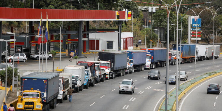 FILE PHOTO: Trailer trucks line up along an avenue to fill up their tanks at a gas station as part of a growing diesel shortage, in Caracas, Venezuela March 5, 2021. REUTERS/Leonardo Fernandez Viloria