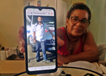 La cubana Anay Hernández muestra una foto de su hijo Adel de la Torre, condenado a siete años de prisión tras ser detenido durante las manifestaciones antigubernamentales del 11 de julio de 2021, durante una charla con EFE el 6 de julio de 2023, en La Habana (Cuba). Anay Hernández se aferra con tristeza a su biblia cuando lee en voz alta una de las cartas de su hijo Adel, preso tras las manifestaciones del 11 de julio de 2021 (11J) en Cuba y, como ella, ferviente cristiano: “Maldito el día en el que nací (...) Dios no está conmigo”. EFE/ Juan Carlos Espinosa