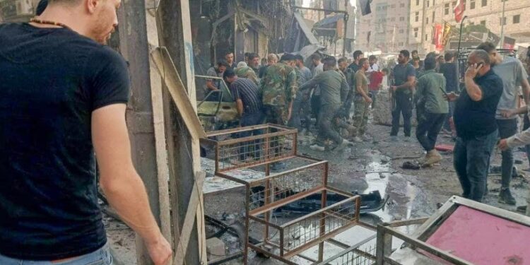 Esta imagen publicada por la televisión siria en su canal Telegram muestra a personas reunidas en el lugar de una explosión en la ciudad de Sayyida Zeinab, en las afueras de Damasco. (Foto: SYRIAN TV / AFP)