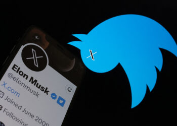 This illustration photo taken on July 24, 2023 shows the Twitter bird logo upside down in the background of Elon Musks screen advertising an "X" as a replacement logo, in Los Angeles. Elon Musk killed off the Twitter logo on July 24, 2023, replacing the world-recognized blue bird with a white X as the tycoon accelerates his efforts to transform the floundering social media giant. Musk and the company's new chief executive Linda Yaccarino announced the rebranding on July 23, 2023, scrapping one of technology's most iconic brands in the latest shock move since the tycoon took over Twitter nine months ago. (Photo by Chris Delmas / AFP)