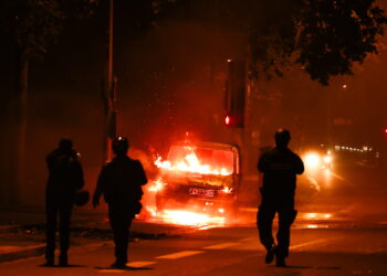 Nanterre (France), 30/06/2023.- People walk next to a car burned during clashes between protesters and riot police in Nanterre, near Paris, France, 30 June 2023. Violence broke out all over France after police fatally shot a 17-year-old teenager during a traffic stop in Nanterre on 27 June. (Protestas, Disturbios, Francia) EFE/EPA/MOHAMMED BADRA