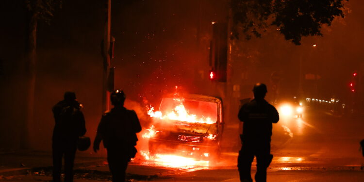 Nanterre (France), 30/06/2023.- People walk next to a car burned during clashes between protesters and riot police in Nanterre, near Paris, France, 30 June 2023. Violence broke out all over France after police fatally shot a 17-year-old teenager during a traffic stop in Nanterre on 27 June. (Protestas, Disturbios, Francia) EFE/EPA/MOHAMMED BADRA