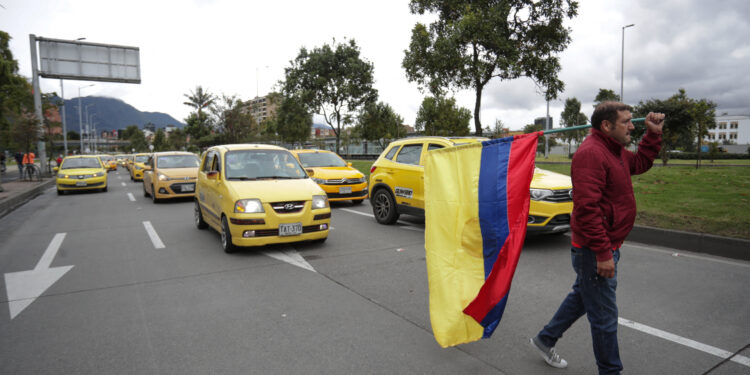 Taxi drivers block the streets during a demonstration against the government's decision to increase the price of gasoline in Bogota, on August 9, 2023. (Photo by Juan Pablo Pino / AFP)