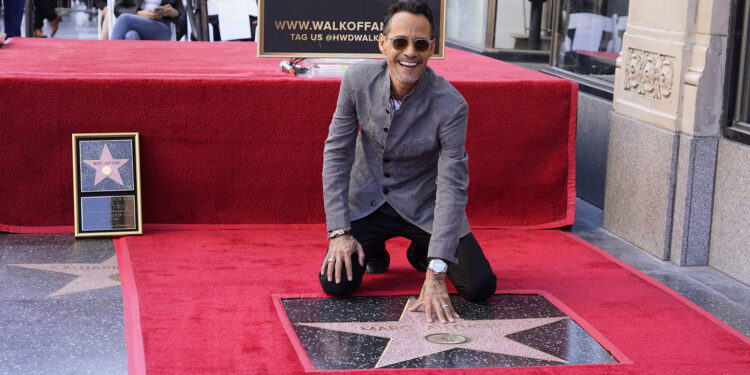 Marc Anthony touches his star during a ceremony honoring him with a star on the Hollywood Walk of Fame Thursday, Sept. 7, 2023, in Los Angeles. (AP Photo/Chris Pizzello)