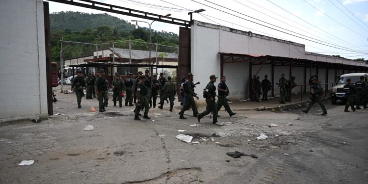 Members of the Bolivarian National Guard (GNB) walk outside the Tocoron prison after authorities seized control of the prison in Tocoron, Aragua State, Venezuela, on September 20, 2023. Venezuela said Wednesday it had seized control of a prison from the hands of a powerful gang with international reach, in a major operation involving 11,000 members of its security forces. (Photo by YURI CORTEZ / AFP)