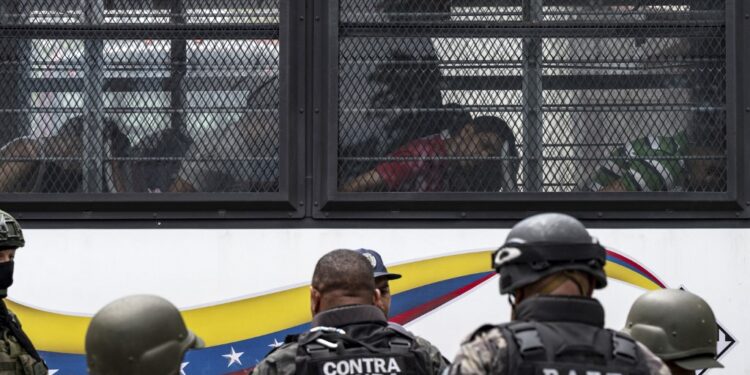 Members of the Bolivarian National Guard (GNB) stand guard as inmates aboard a bus are transferred outside the Tocoron prison in Tocoron, Aragua State, Venezuela, on September 20, 2023. Venezuela said Wednesday it had seized control of a prison from the hands of a powerful gang with international reach, in a major operation involving 11,000 members of its security forces. (Photo by Yuri CORTEZ / AFP)